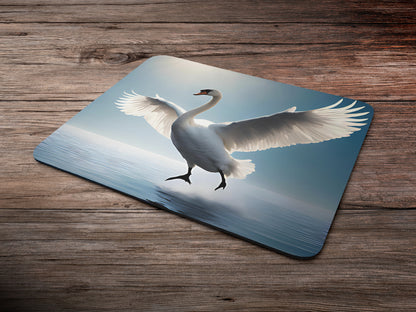 Swan in mid-flight, with its wings fully extended against a clear blue skymousepad mockup style 6